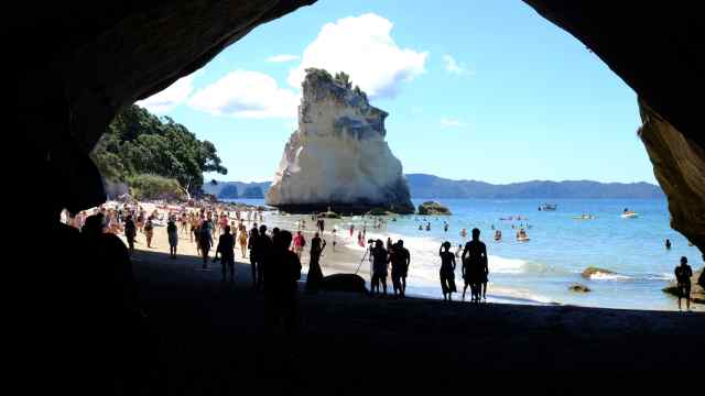 Limestone arch, rock and people on beach